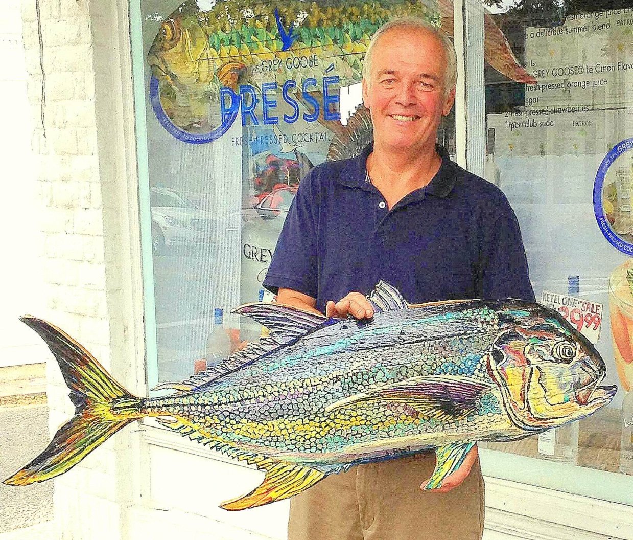 John Rist holding one of his fish paintings